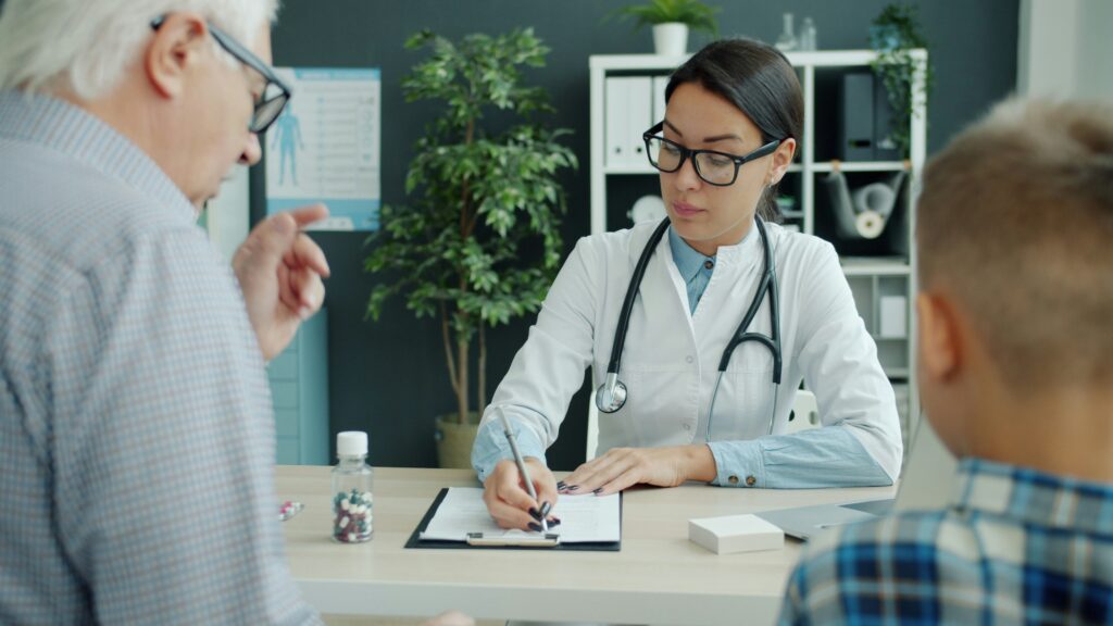 Doctor consults with elderly man and child.
