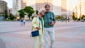 Happy senior couple walking in plaza de espana madrid enjoying vacation