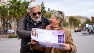 Happy senior couple doing tourism guiding by a paper map in the city
