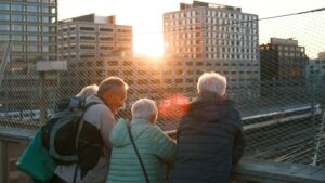 People watching sunset over city buildings
