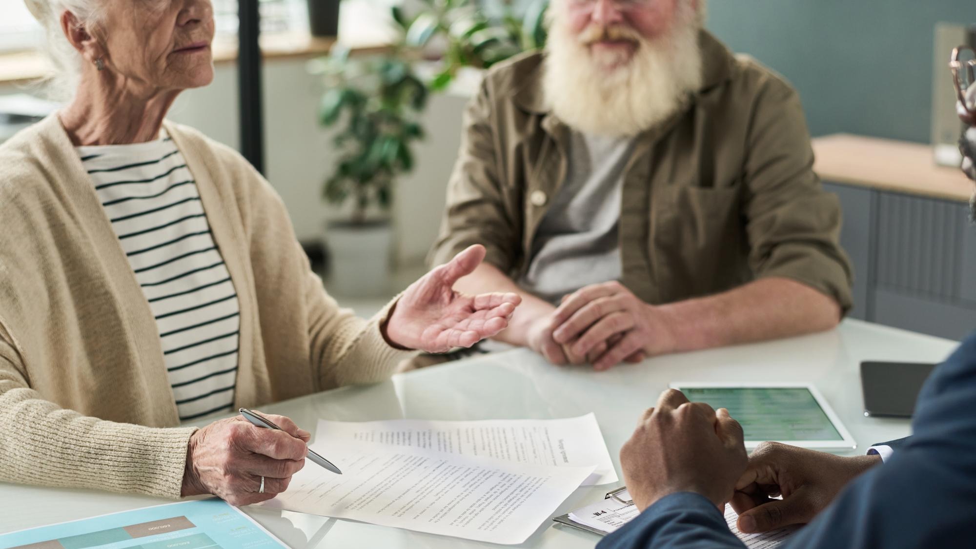 Senior people signing contract in office
