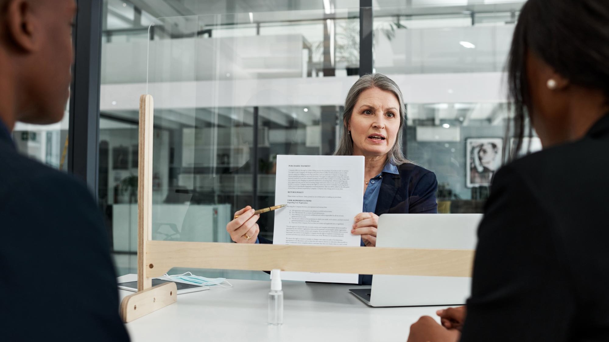 Safety checks are part of our protocol Shot of a mature businesswoman having a meeting with a sneeze guard in a modern office Safety checks are part of our protocol Shot of a mature businesswoman having a meeting with a sneeze guard in a modern office