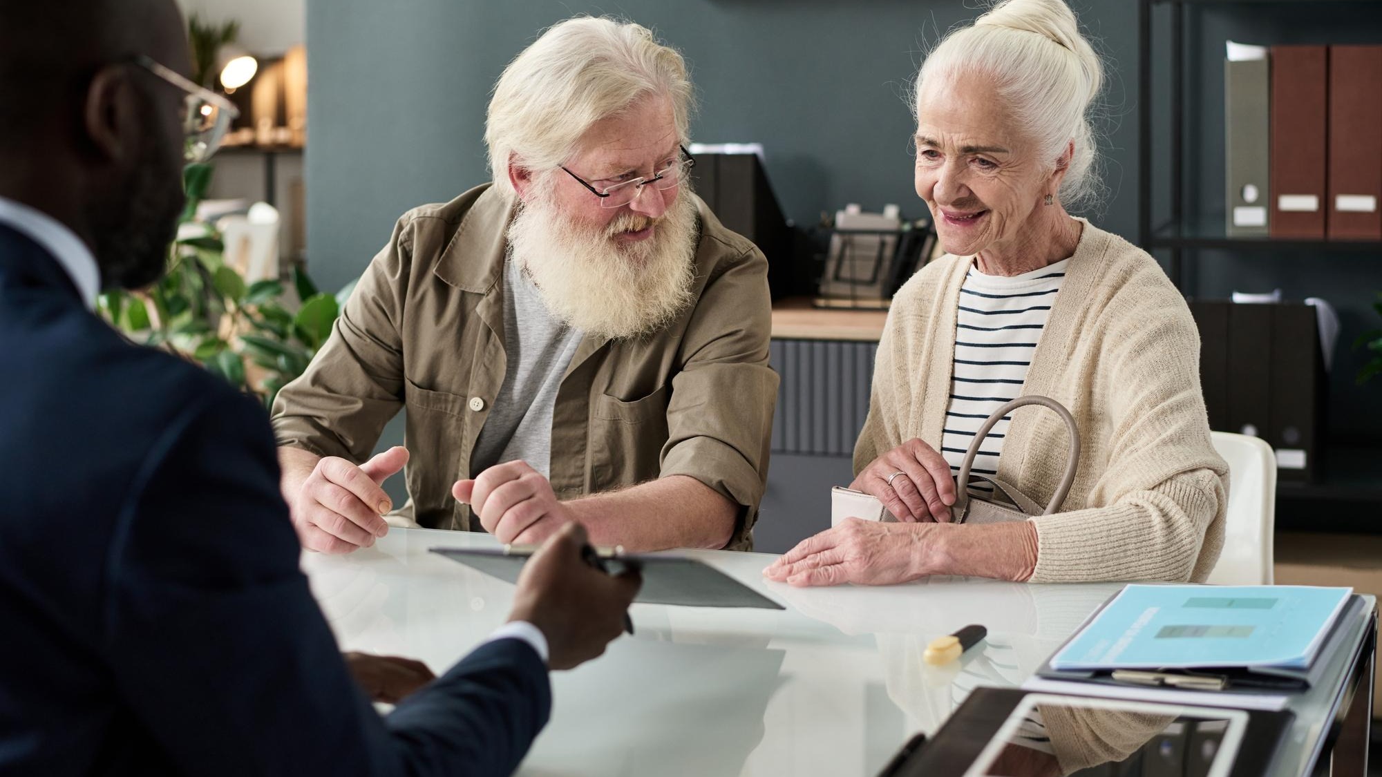 Senior couple applying pension in financial agency Senior couple applying pension in financial agency
