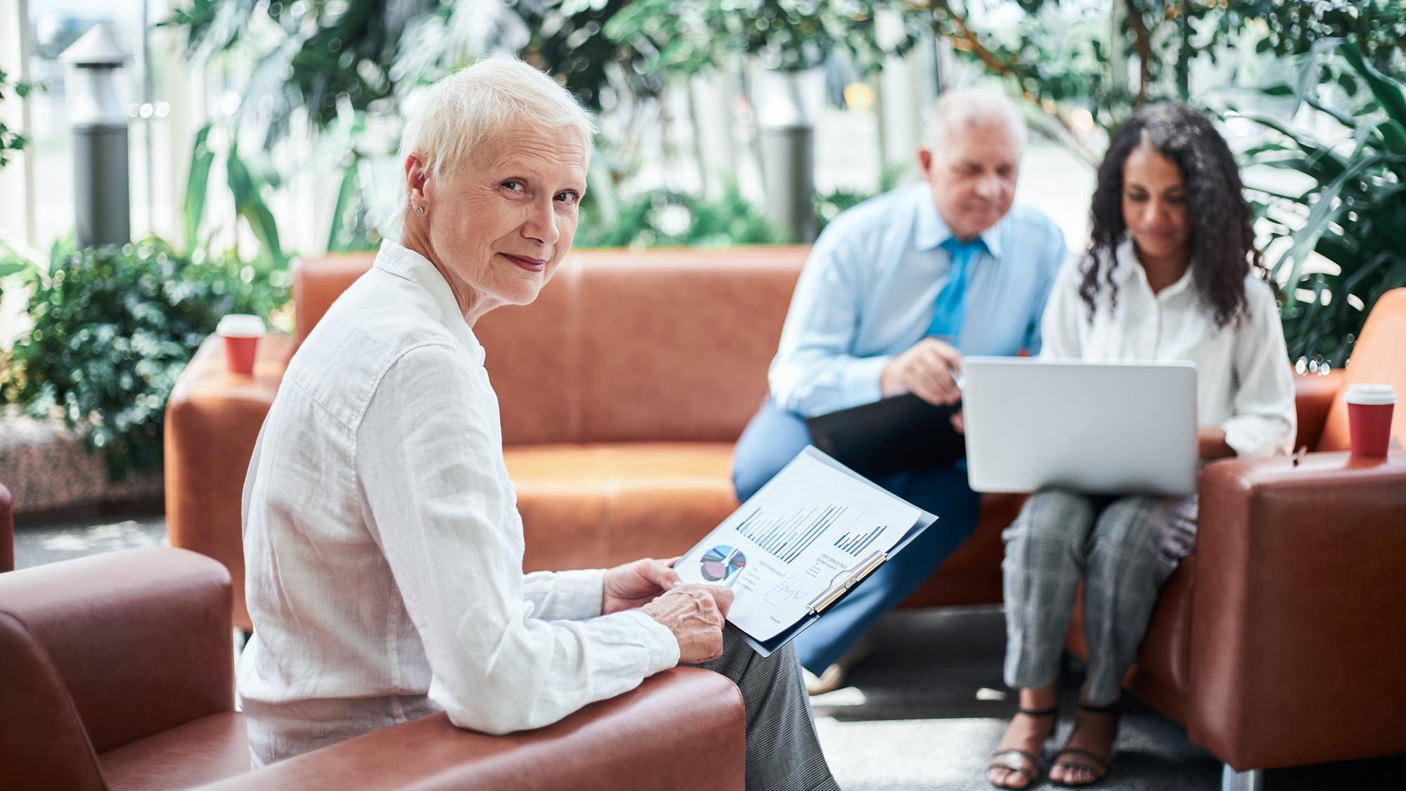 Businesswoman with a financial report sitting in the office lobby Businesswoman with a financial report sitting in the office lobby