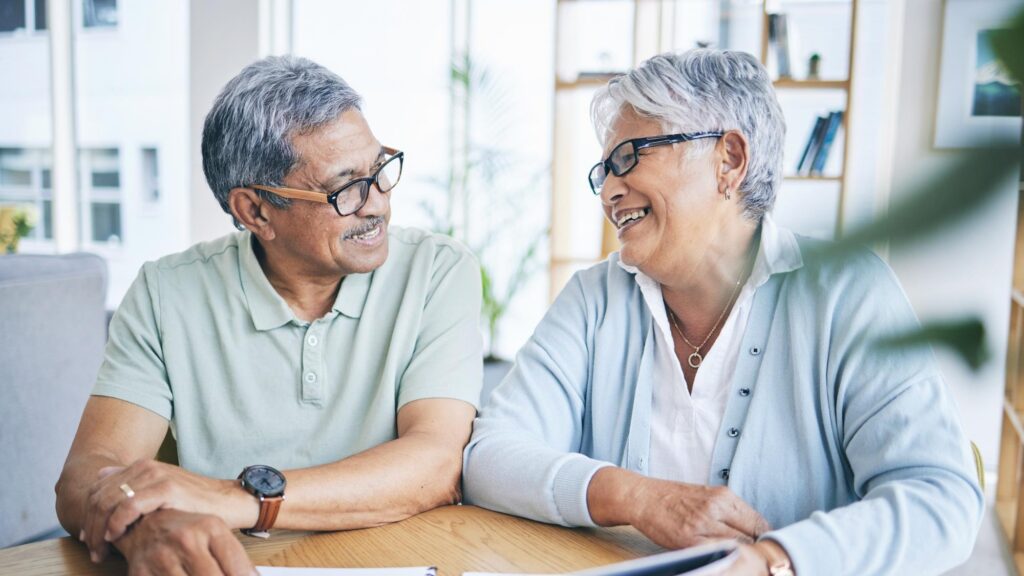 Old couple smile and financial planning with documents in home for pension savings or tax Elderly man and happy woman with budget investment and mortgage paperwork for insurance in retirement