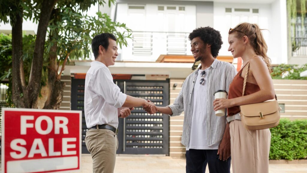 Positive diverse young couple greeting real estate agent in new district
