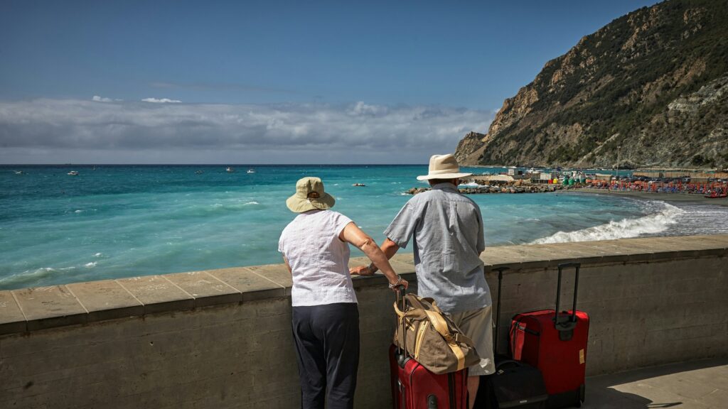 man and woman standing beside concrete seawall looking at beach