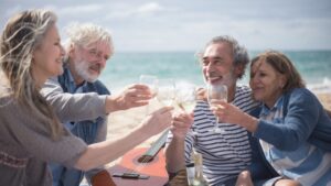 Senior friends enjoying wine on a beach vacation in Portugal.