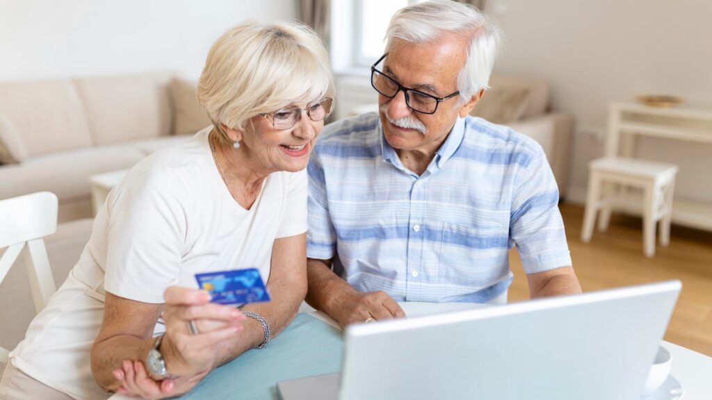 Senior Couple Using Laptop To Shop Online Elderly couple paying bills online on laptop