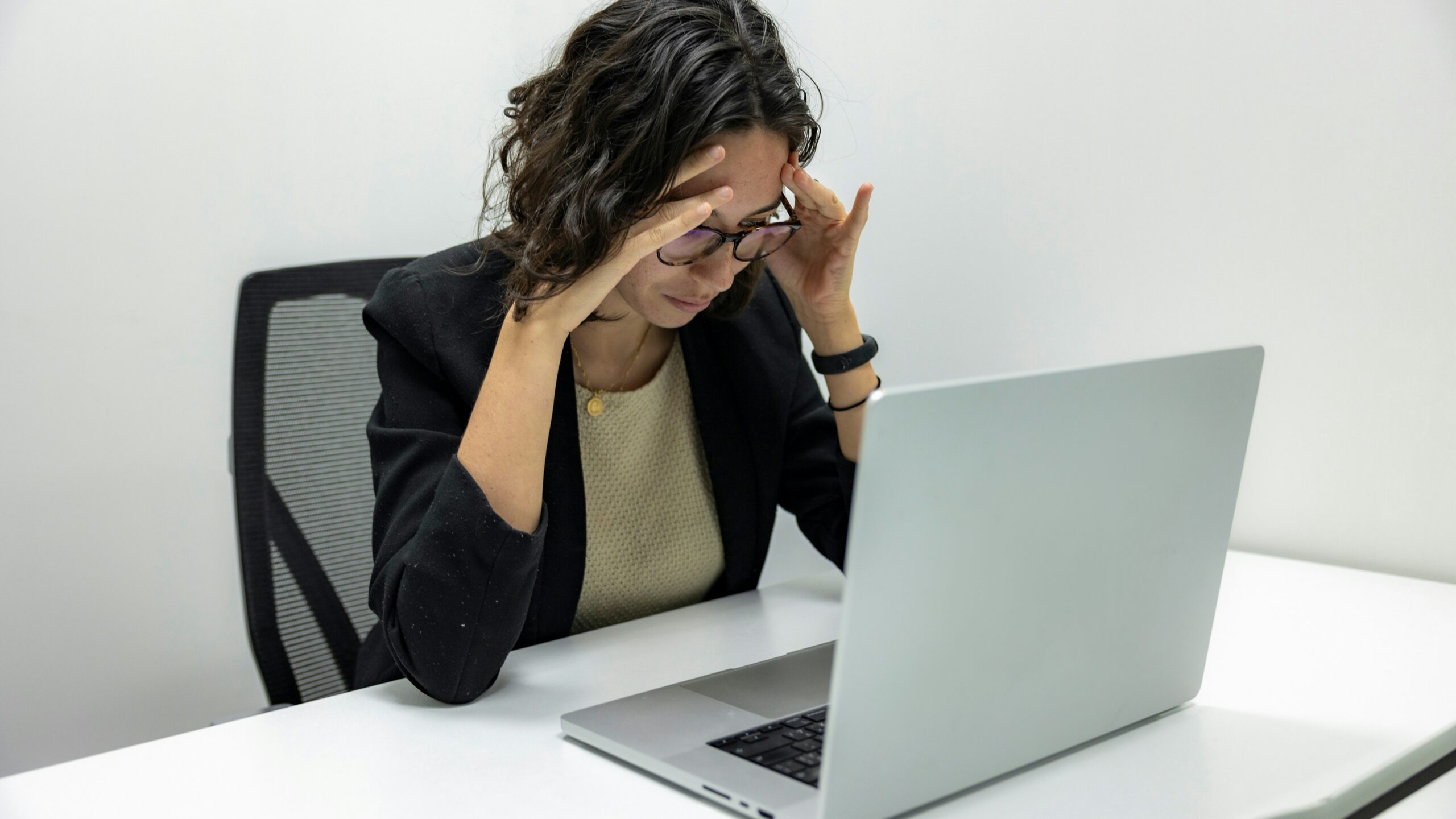 a woman sitting in front of a laptop computer a woman sitting in front of a laptop computer