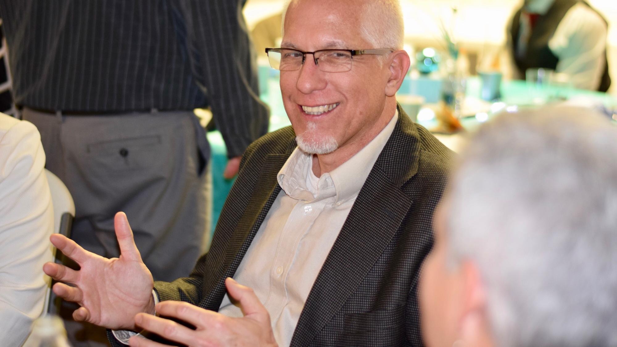 Smiling man talking with colleague Smiling man talking with colleague